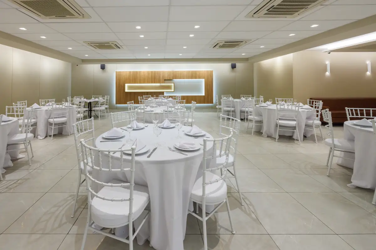 Salão de Eventos montado com mesas redondas brancas